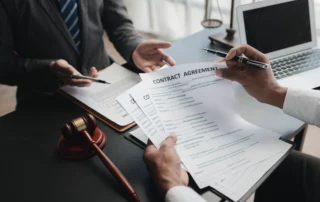 Business professionals reviewing contract with gavel, representing employment agreements, workplace policies, and legal protection against employee lawsuits