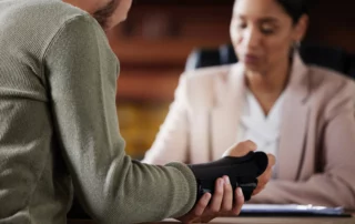 Injured person showing wrist brace during consultation, representing medical evaluation and legal guidance for a slip and fall personal injury claim